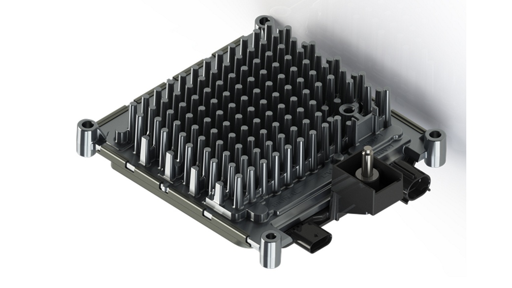 A metallic heat sink component with numerous vertical fins designed for efficient cooling. It is mounted on a rectangular base with four circular support structures at each corner, and has an attached connector for power or data transfer.