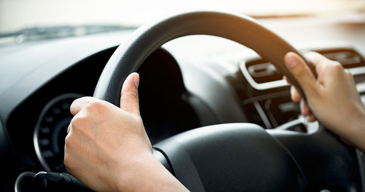 A woman's hand holding a car steering wheel,represents the correct car steering wheel. In order to prevent accidents.Show driving safe step.