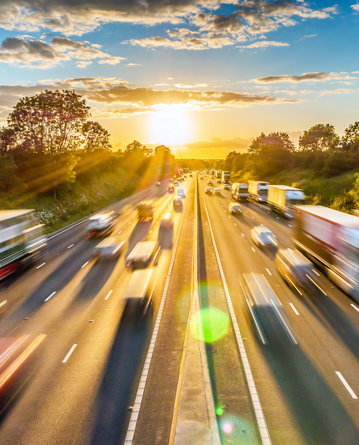 heavy traffic moving at speed on UK motorway in England at sunset.