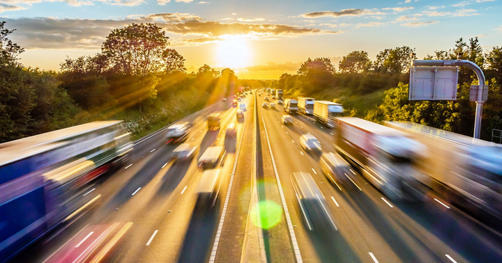 heavy traffic moving at speed on UK motorway in England at sunset.