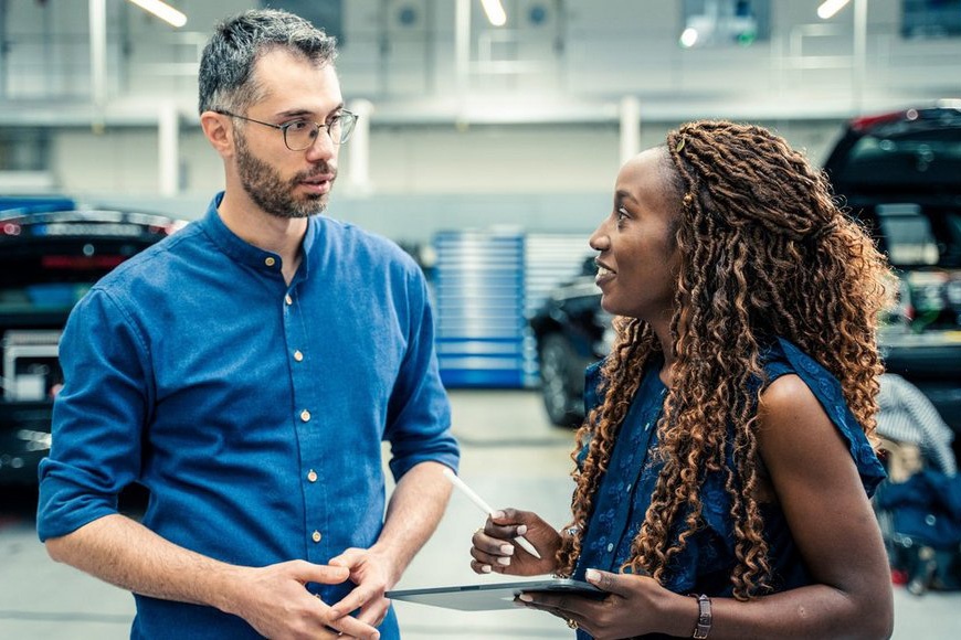 A man and a woman stand in a production hall